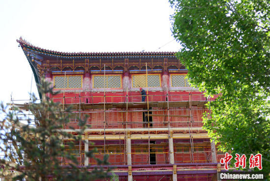 圖為5月上旬，甘肅山丹縣大佛寺內(nèi)，工作人員對(duì)古建筑大雄寶殿進(jìn)行修繕。 中新社記者 高展 攝