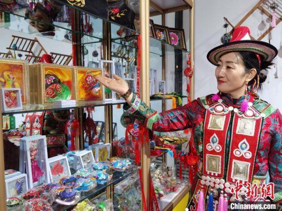 圖為身著民族服飾的隴原巧手展示手工藝品。(資料圖) 徐雪 攝
