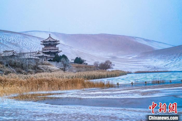 2021年11月28日，雪落鳴沙山月牙泉景區(qū)?！⊥醣筱y 攝