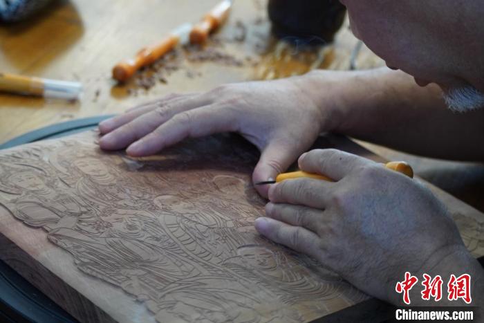 圖為徐晉林湊近木板，近距離制作雕版畫?！【琶赖┰?　攝