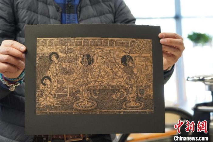 圖為手工書藝人展示敦煌雕版壁畫印刷品?！【琶赖┰?　攝
