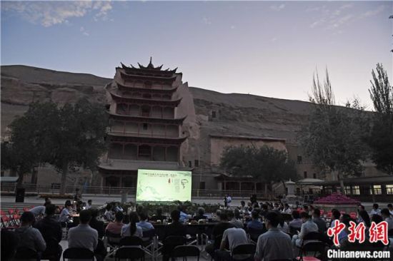 2018年8月，在敦煌莫高窟標(biāo)志性建筑“九層樓”前，《回顧平山郁夫先生的貢獻(xiàn)》座談會(huì)舉行。來自中日兩國的專家、學(xué)者共同懷念這位情系敦煌數(shù)十載的繪畫巨匠、中日友好的文化使者、世界文化遺產(chǎn)的守護(hù)者。中新社記者 楊艷敏 攝