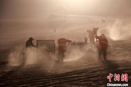 圖為敦煌市鳴沙山月牙泉景區(qū)“駱駝保姆”清理駱駝糞便?！垥粤?攝