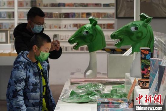 圖為“神馬來了”銅奔馬頭套吸引參觀者駐足。　九美旦增 攝