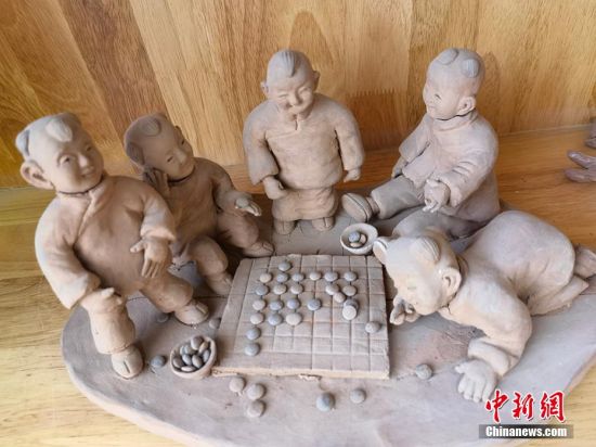 圖為泥塑作品展現(xiàn)下棋場(chǎng)景。 劉玉桃 攝