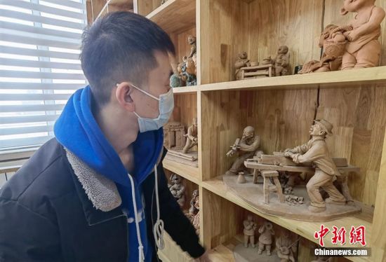 圖為學(xué)生欣賞泥塑作品。 劉玉桃 攝