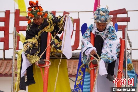 圖為“苦水高高蹺”表演者通過麻繩將腳固定在腳踏板，并在腿部纏繞六七圈?！【琶赖┰?攝