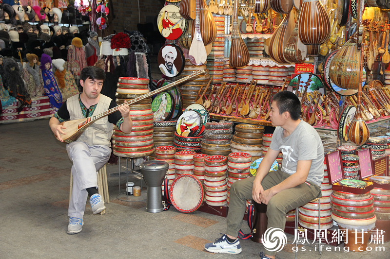 烏魯木齊二道橋巴扎內(nèi)，店主正在向客人展示樂器。楊文遠(yuǎn) 攝