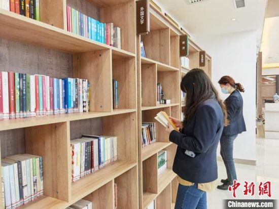 圖為在甘肅公航旅建設(shè)集團(tuán)有限公司的職工書屋，職工挑選書籍。　徐雪 攝