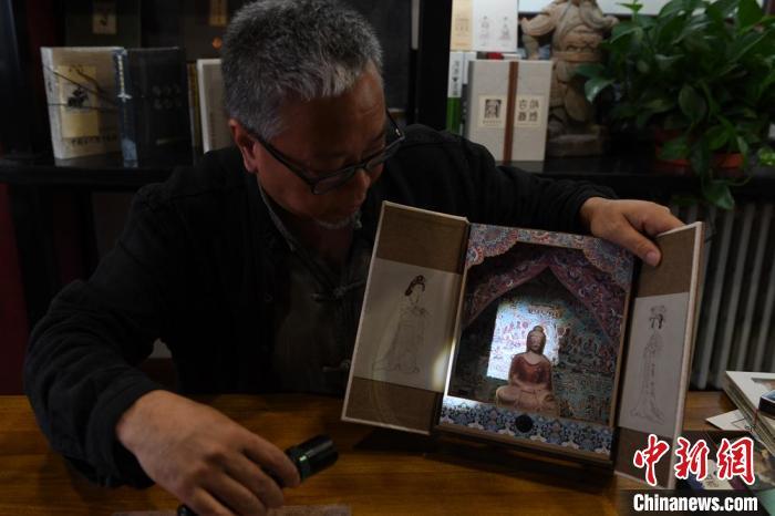 圖為讀者出版集團(tuán)讀者晉林工作室獨(dú)立出品人徐晉林，展示互動性強(qiáng)的敦煌題材手工書。(資料圖) 楊艷敏 攝