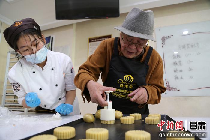 當(dāng)日，受邀參加活動(dòng)的臺(tái)胞臺(tái)屬代表、兩岸婚姻及子女、在甘臺(tái)商代表等歡聚一堂。圖為77歲的在甘臺(tái)胞潘天鑒制作月餅。九美旦增 攝