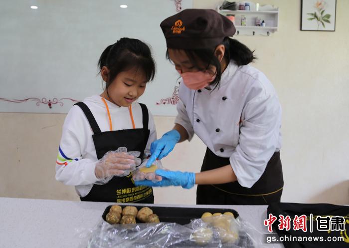 圖為在甘臺(tái)胞小朋友在工作人員指導(dǎo)下制作月餅。九美旦增 攝