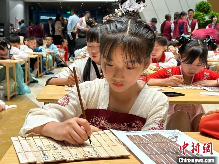 圖為小朋友在甘肅簡(jiǎn)牘博物館練習(xí)書法?！≈行律缬浾?戴文昌 攝