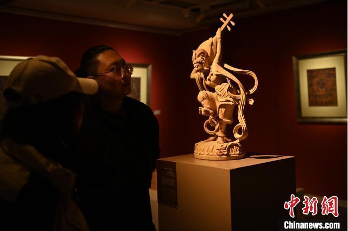 圖為季茂杰向參觀者介紹自己創(chuàng)作敦煌木雕的過(guò)程。李亞龍 攝</p>
<p>