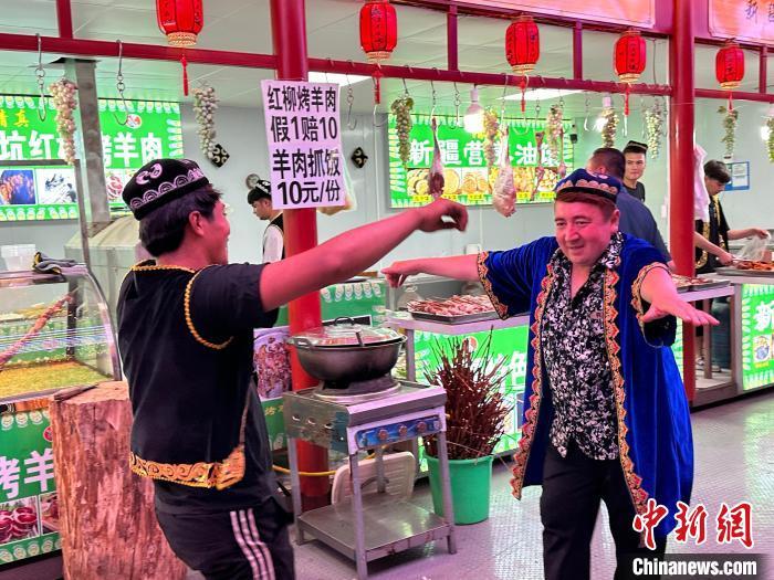 圖為餐飲經(jīng)營者在“西涼不夜城”跳起舞蹈引客?！〈魑牟?攝</p><p>