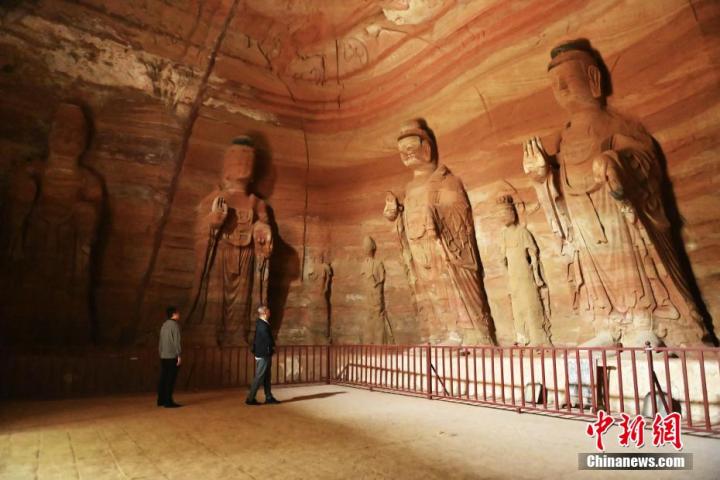 7月15日，游人參觀甘肅省平?jīng)鍪袥艽h百里石窟長廊中的南石窟寺1號窟。百里石窟長廊位于涇川縣境內(nèi)，由512個石窟、5眼窟中石井組成，現(xiàn)存王母宮石窟、鳳凰山石窟、南石窟寺、丈八寺石窟、羅漢洞石窟、太山寺石窟等規(guī)模較大的石窟群，還有數(shù)量眾多的小石窟群。南石窟寺開鑿于北魏永平三年，其中1號窟屬于大型七佛窟，七佛高達(dá)6米。中新社記者 李亞龍 攝